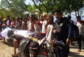 a group of people standing around a man in a wetsuit