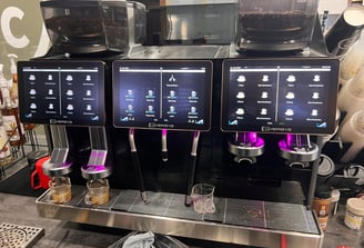 Eversys triple-group super-automatic espresso machine with touchscreen interface.