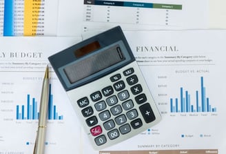 a calculator and pen on a desk with a pen and a pen