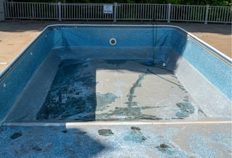 a pool with a blue pool and a white fence