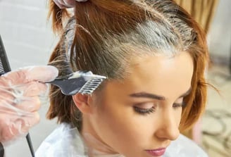 a woman is getting her hair cut by a hairdressucker