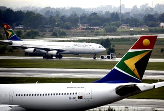 two airplanes are parked on the runway at an airport,Acsa