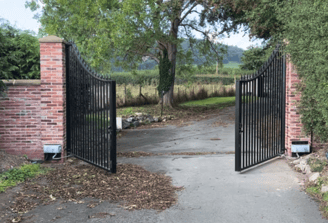 a gated in area with a brick wall and a gated in area with automated gates