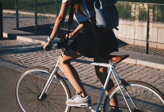 a woman riding a bicycle with a backpack on it