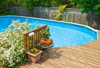an above ground pool with a custom built deck with stairs