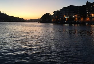 A sunset over the Douro river with a bridge and buildings
