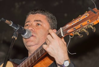 a man with a guitar and a microphone in front of a microphone