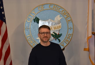 a portrait of the candidate in front of the Chicopee seal