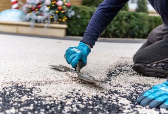 a person wearing gloves and gloves is using a pair of scissors to cut a piece
