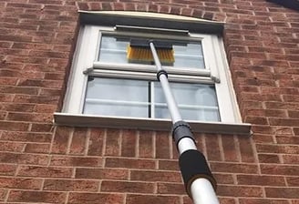 window being cleaned with an extension pole on house in malvern