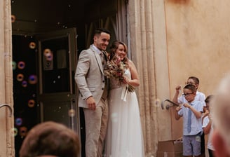 couple de jeune mariés sur les marches de l'église