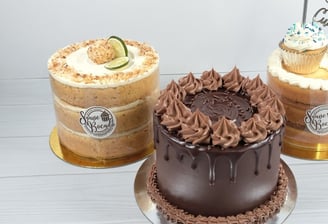 three cakes with chocolate frosting and frosting on them