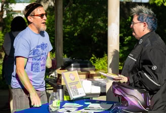 Two people talking over a table with printed resources on it