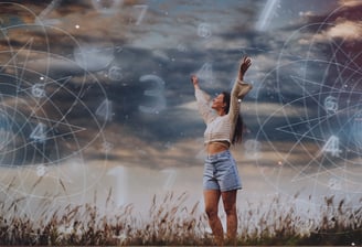 Woman with arms raised, standing in a field with dark sky, astrology and numerology symbols