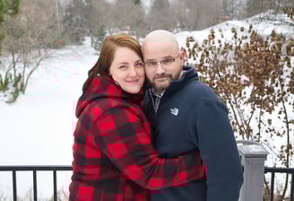 a man and woman standing in the snow