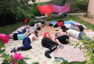 a group of people sitting on a blanket on a blanket, rilassamento, classe bioenergetica