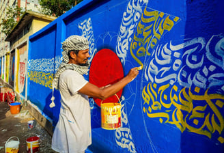 Imagem de um homem grafitando um muro