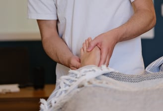 Thomas Busson pratique la réflexologie plantaire sur son client pour un soulagement immédiat