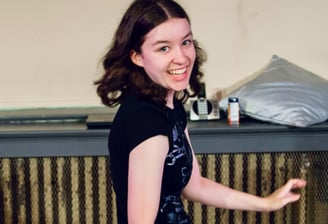 A preteen girl dances giddily as she spins to look at the camera