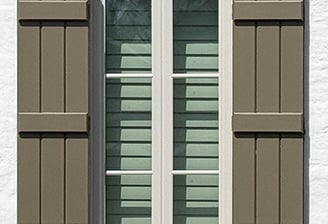 exterior board and batten shutters in brown on white brick