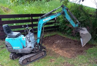 Small digger and scrapped off garden as an example of plant hire available