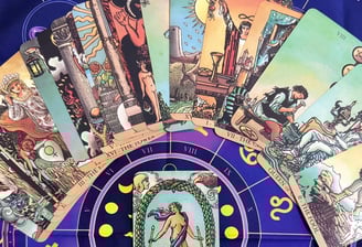 Manos sosteniendo cartas del tarot sobre mesa de madera: El Loco, La Sacerdotisa y El Sol - Lecturas