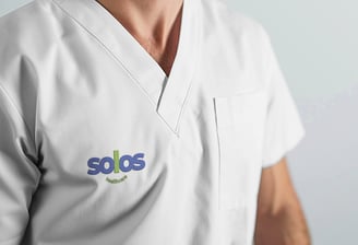 A healthcare uniform with the Solos logo on