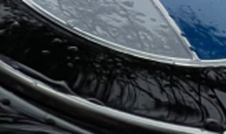 bmw logotipas ant automobilio variklio dangčio po to, kai jis buvo padengtas hidrofobiniu sluoksniu