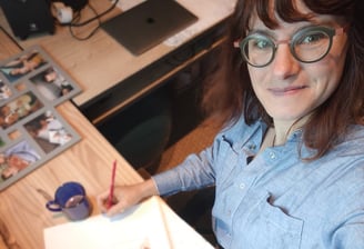 portrait de Marie Hardy fondatrice de Fresh Fresque devant un croquis à main levée à son bureau