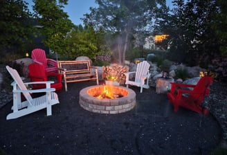 Cozy backyard fire pit with Adirondack chairs and ambient lighting in London, Ontario.