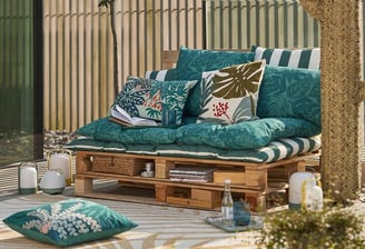 a couch with pillows and pillows on a patio