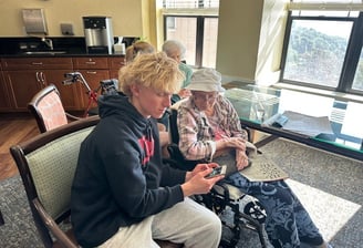 teen helps older woman learn dictation on her iphone
