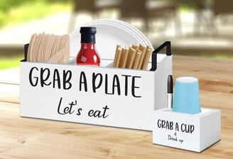 a wooden crate with a sign that says grab a plate let's eat