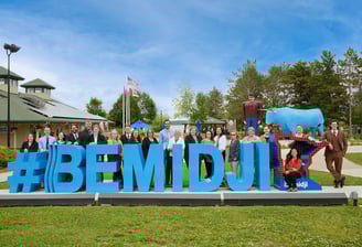 a group of people standing in front of a sign that says bemidji