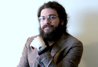 a man with a beard and glasses on a chair