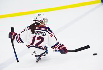 a woman in a hockey uniform is playing sled hockey