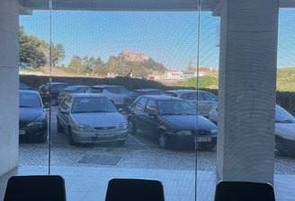 a row of chairs in a room with a view of a parking lot