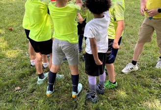 a group of children playing soccer in a field