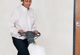 a woman is cleaning a floor with a floor cleaning machine