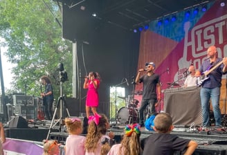 LuxeBand performing at an outdoor festival for an audience of children