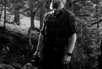 Homme debout dans une forêt.