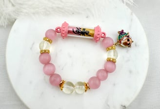 Bracelet Features pink and clear rounded beads alternating in color. It has a central element with 