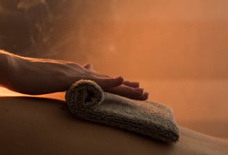 Massage du dos d'une femme avec serviette chaude