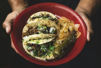 a person holding a plate with a plate of tacos, Street Local at Tacos Mixes Los Angeles