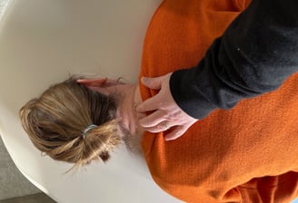a woman in orange lying on her stomach, the patrician with her hand on her occiput