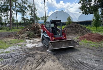 a tractor with a loader on a dirt road
