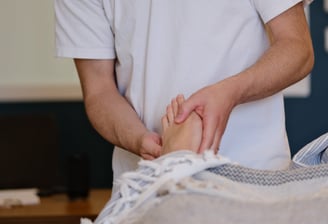 Thomas Busson pratique la réflexologie plantaire sur son client pour un soulagement immédiat
