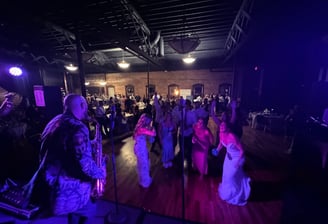 LuxeBand singer playing saxophone on stage for a crowd at a wedding