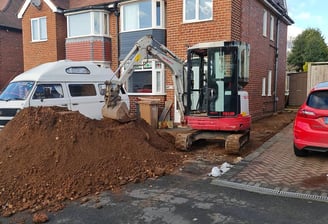 Digger picking up sand on a Dudley driveway during garden project
