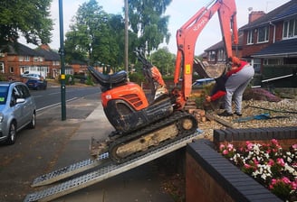 Mini digger being unloaded in Birmingham for groundwork services